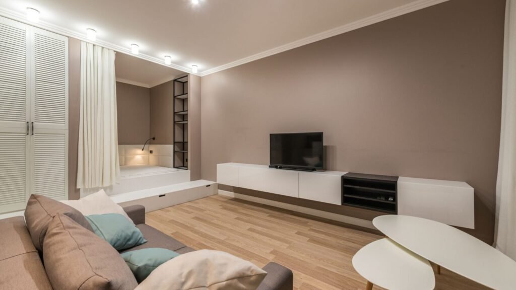 Modern living room with beige decor, neutral upholstery, and warm wood flooring.