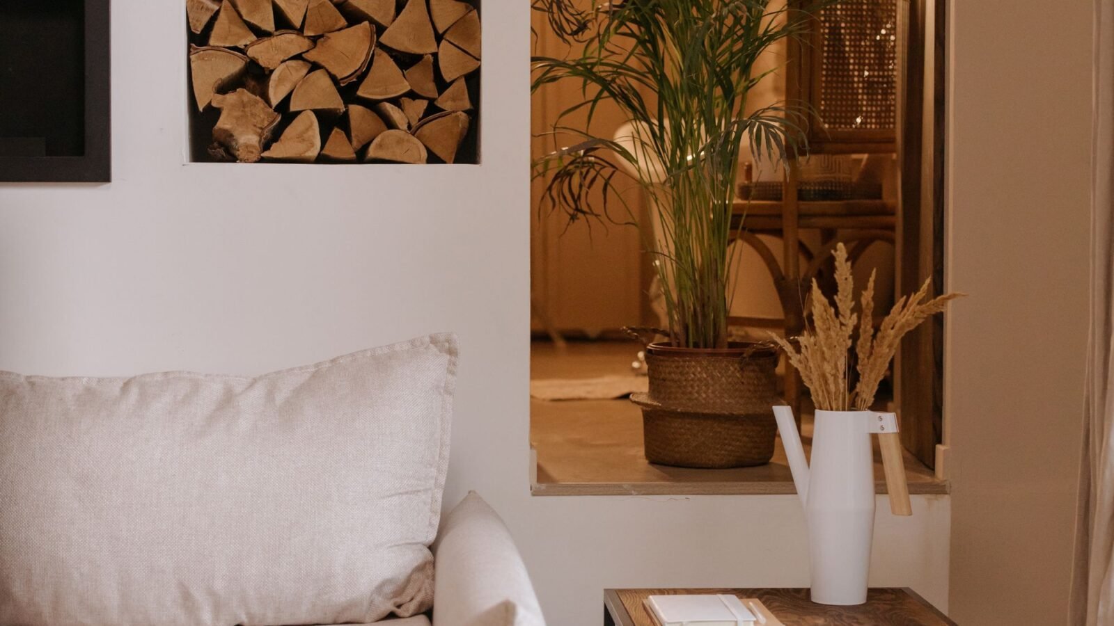 Tidy cozy living room with beige seating, indoor plants, and natural textures.