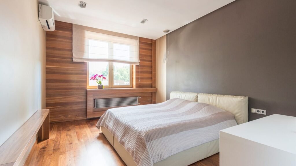 Bright modern bedroom with neutral bedding, wood accents, and natural light.