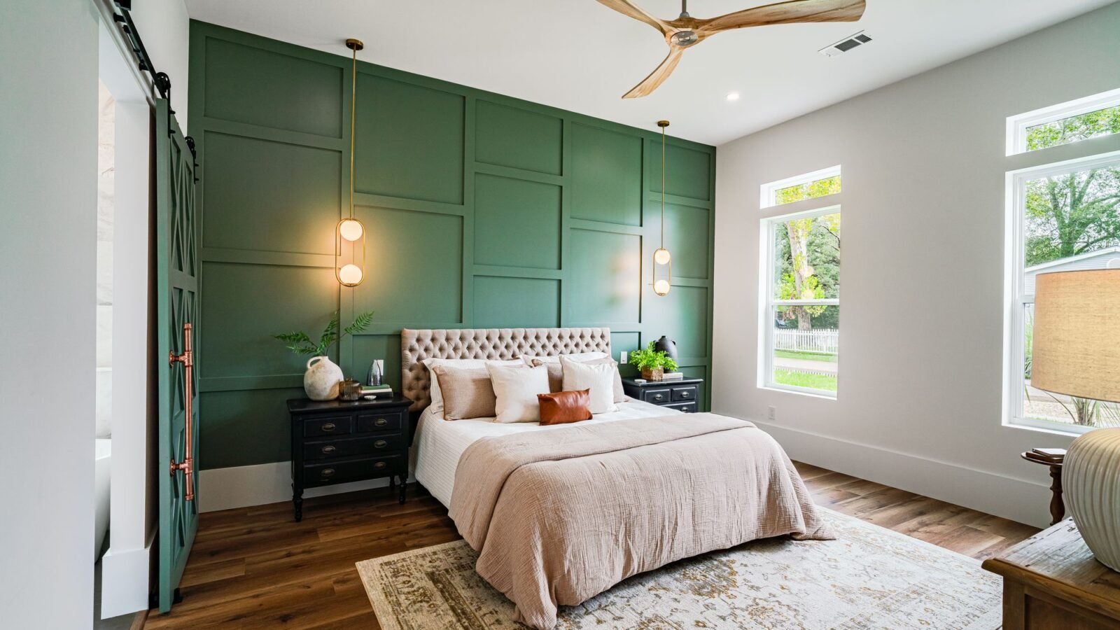 Stylish bedroom with a green accent wall, neutral bedding, and natural light.