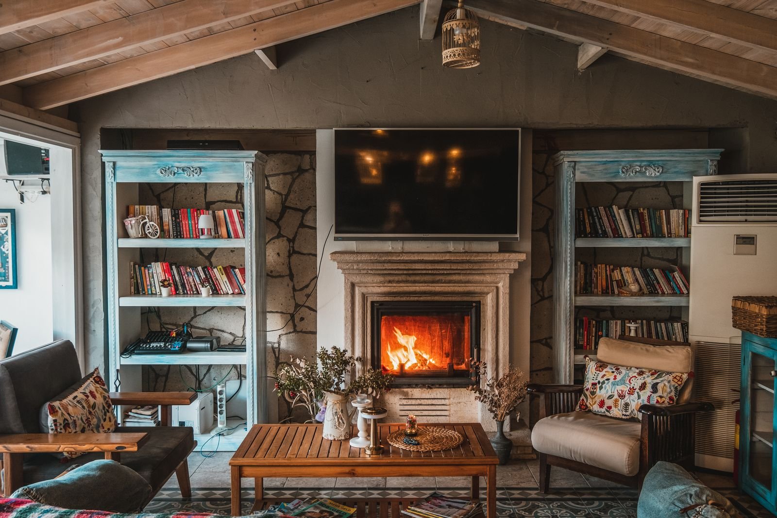 Cozy fall living room with a lit fireplace, warm textiles, and layered autumn decor