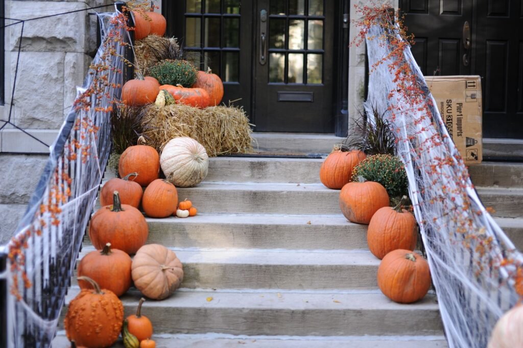 Autumn porch decorated with pumpkins and fall foliage on the steps