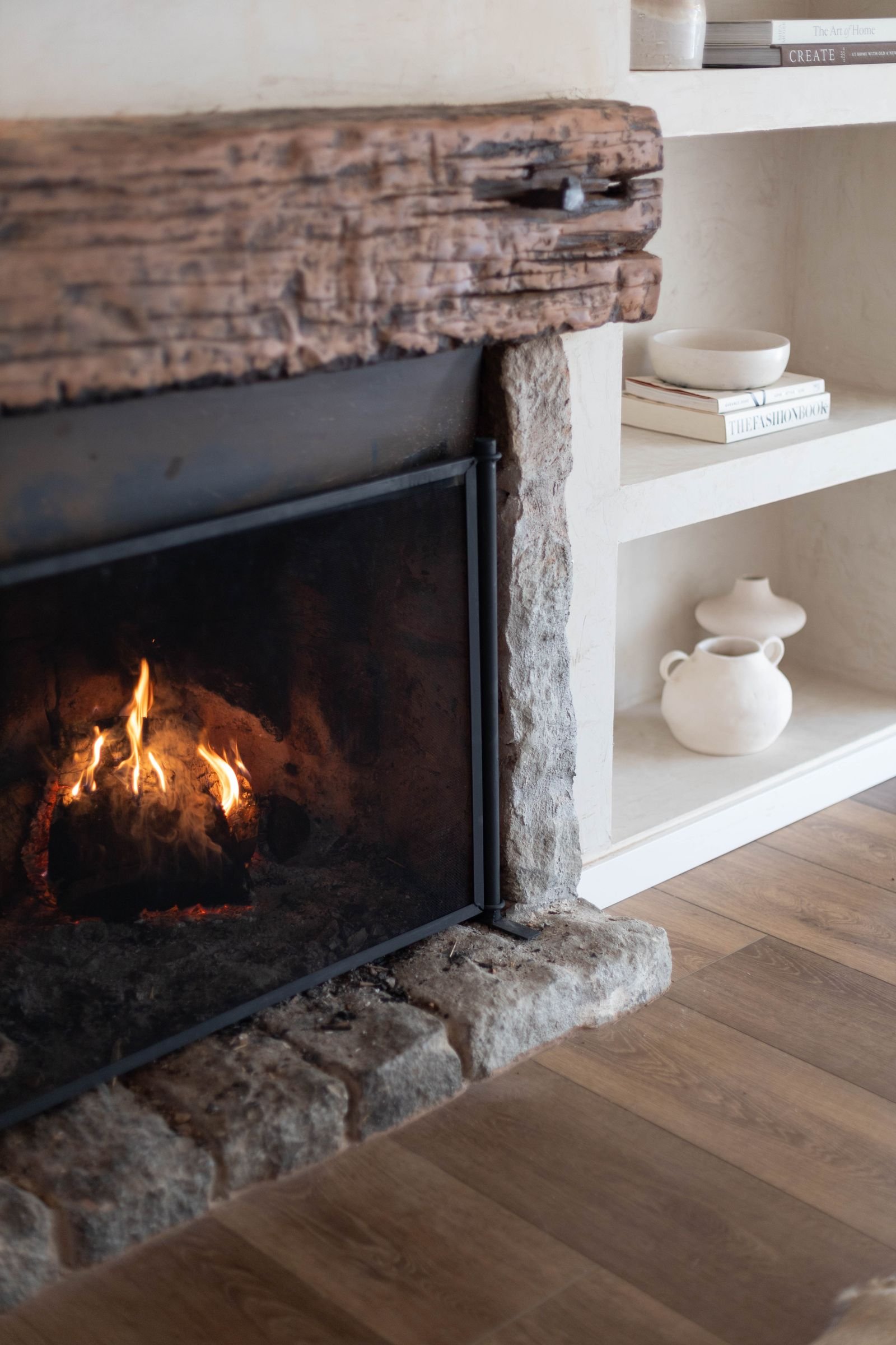 Cozy living room fireplace with a styled wooden mantel