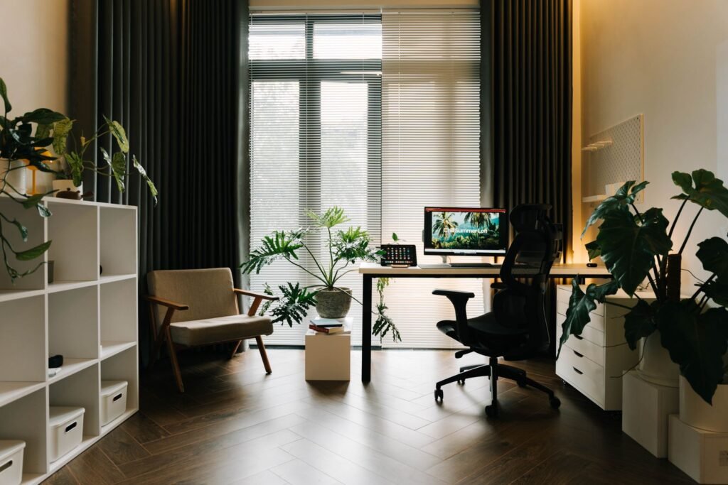 Bright modern home office with a wooden desk, ergonomic chair, and plants
