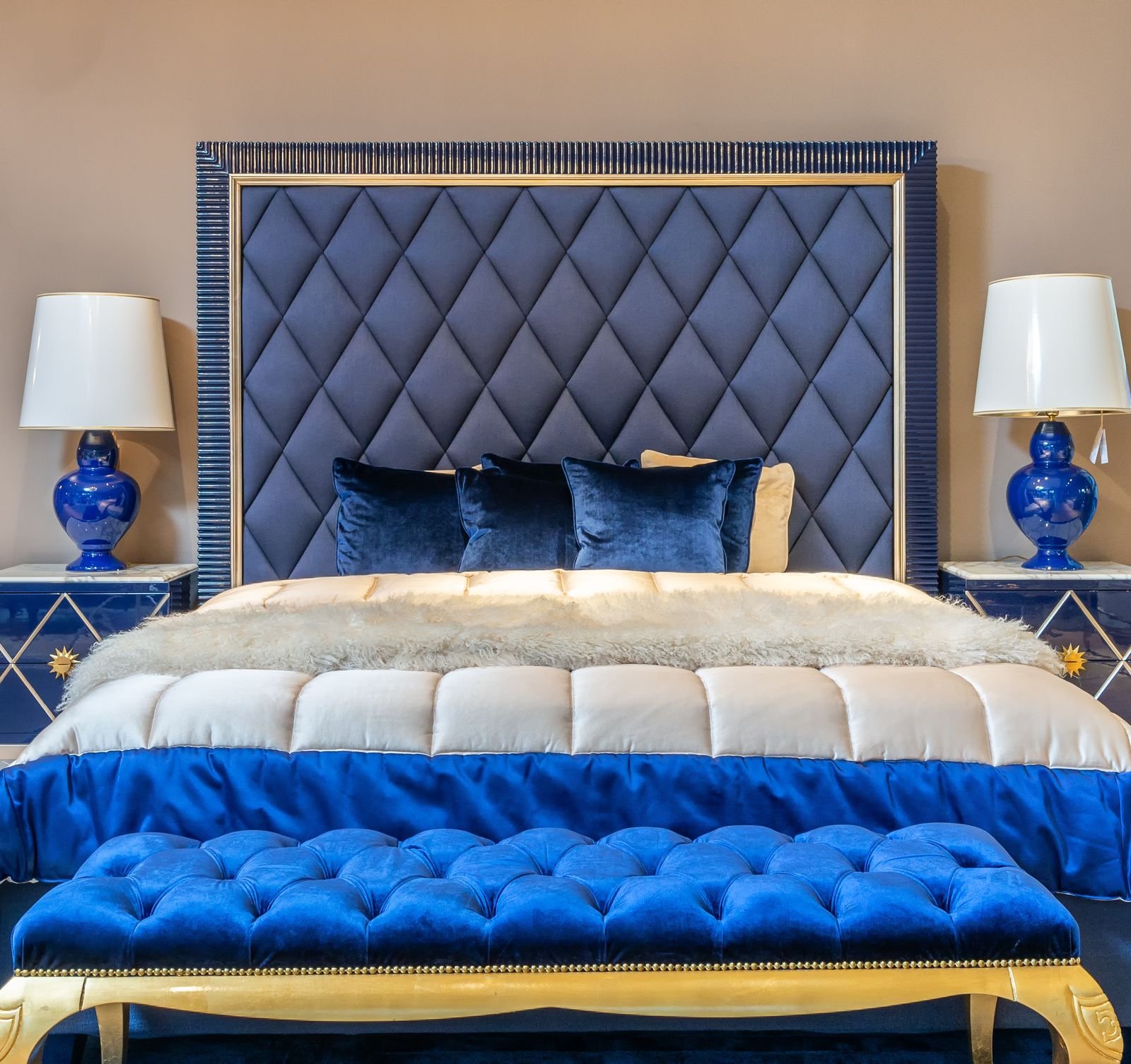 Elegant navy blue bedroom with a tufted headboard and cozy bedding