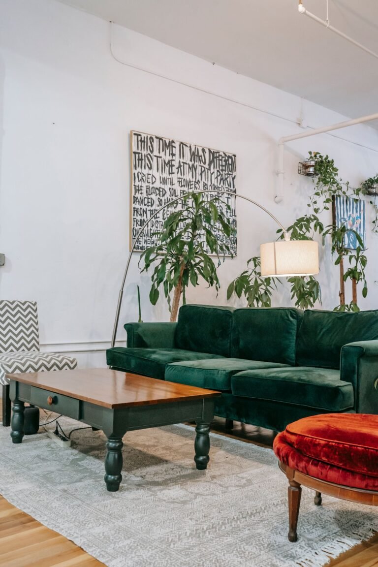 Living room with an olive green velvet sofa and lush plants